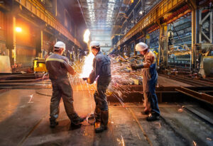 Een weergave van een industriële werkomgeving waar 3 manen werken in beschermende werkkleding met PBM’s