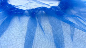Afbeelding van een close-up van blauw non-woven materiaal met fijne structuur.