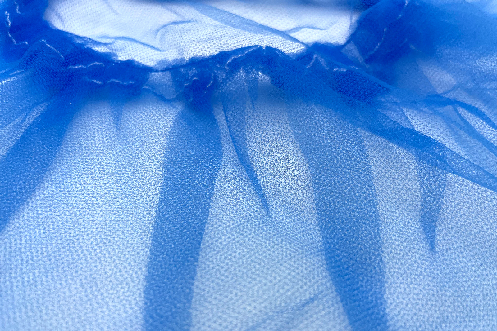 Afbeelding van een close-up van blauw non-woven materiaal met fijne structuur.