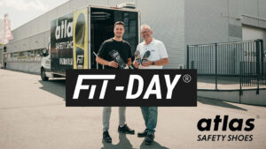 Twee personen staan voor een Atlas Safety Shoes-demovoertuig tijdens een FIT-DAY evenement, met Atlas-logo en FIT-DAY branding in beeld.
