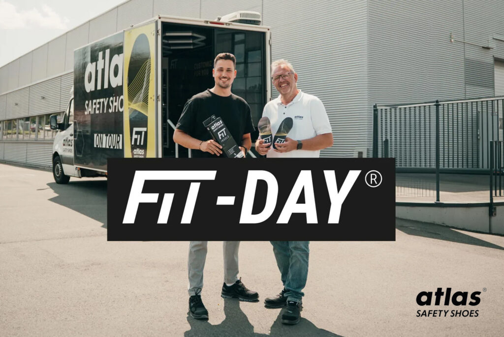 Twee personen staan voor een Atlas Safety Shoes-demovoertuig tijdens een FIT-DAY evenement, met Atlas-logo en FIT-DAY branding in beeld.