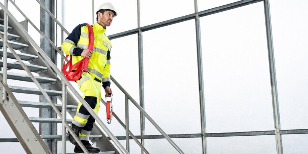 Medewerker in BallyClare multinorm werkkleding met high-visibility eigenschappen op een industriële locatie