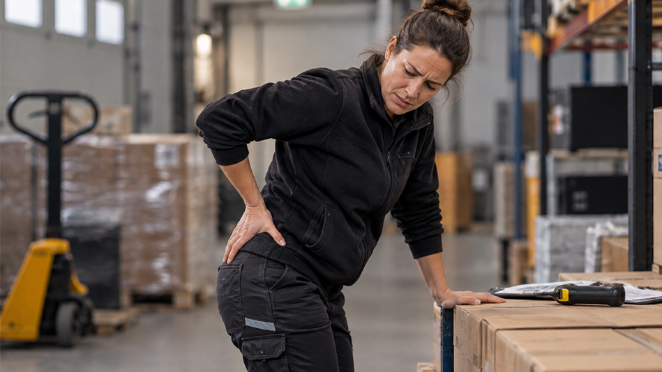 Magazijnmedewerker met pijn aan haar heup tijdens het werk.