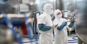 Illustration of food safety with a hygienic working environment, protective equipment and control elements such as checklists and detection systems.