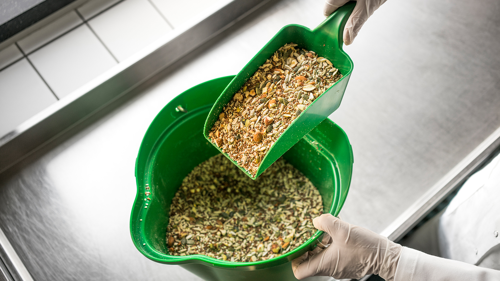 Green hand scoop and green bucket with animal feed