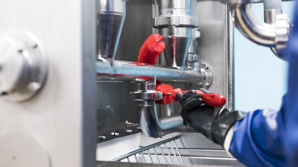 Close-up photo of a machine being cleaned with a Vikan tube cleaner