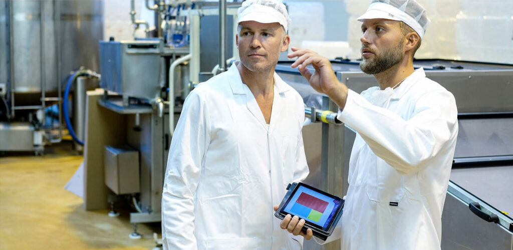 Two employees discussing colour coding in a production area