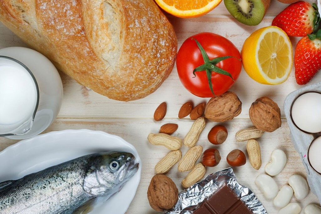 Image of various foods such as fish, bread, fruit, and nuts on a table