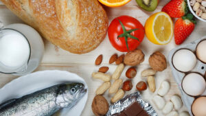 Image of various foods such as fish, bread, fruit, and nuts on a table