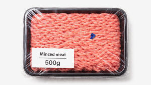 Pack of 500g minced beef in a plastic tray with a small blue plastic fragment inside