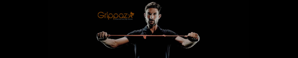 Image of a man stretching orange elastic material against a black background