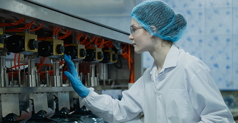 Female employee carrying out work in protective hygiene clothing